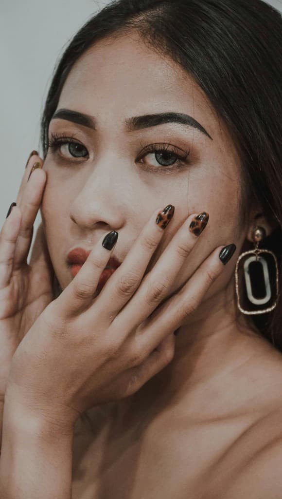 Model wearing tortoiseshell gel nail wraps